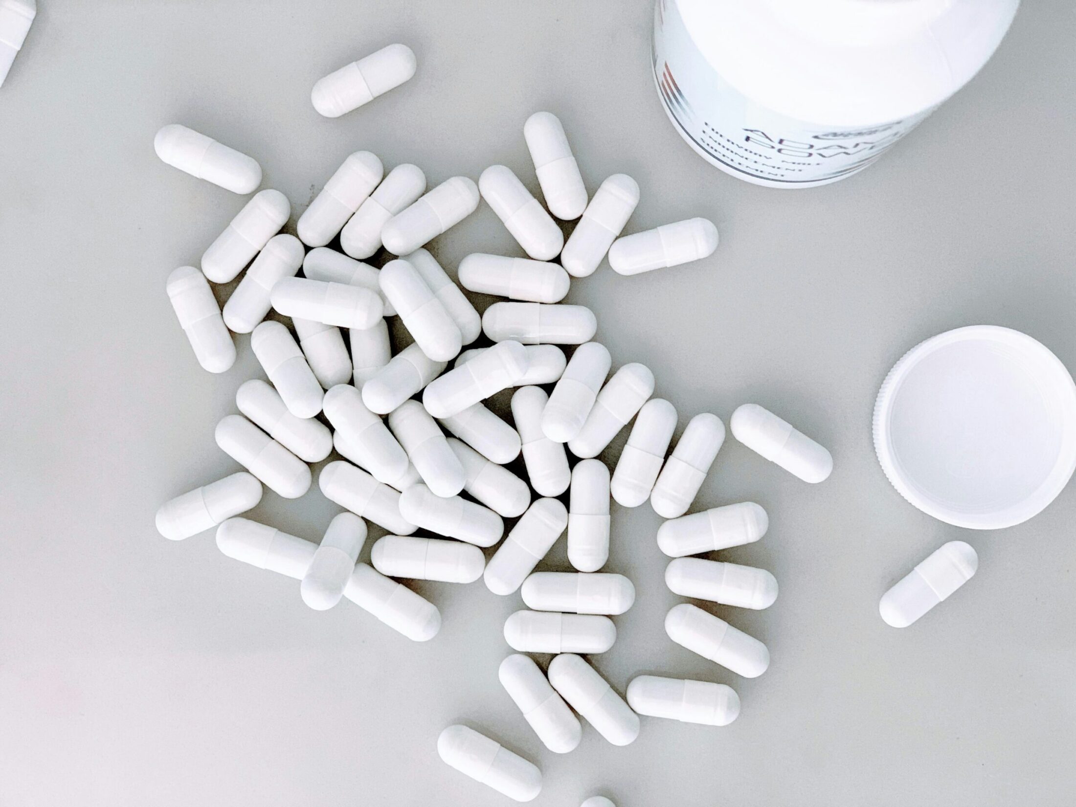 White metformin pills, some loose with a blurred background suggesting a medical setting.